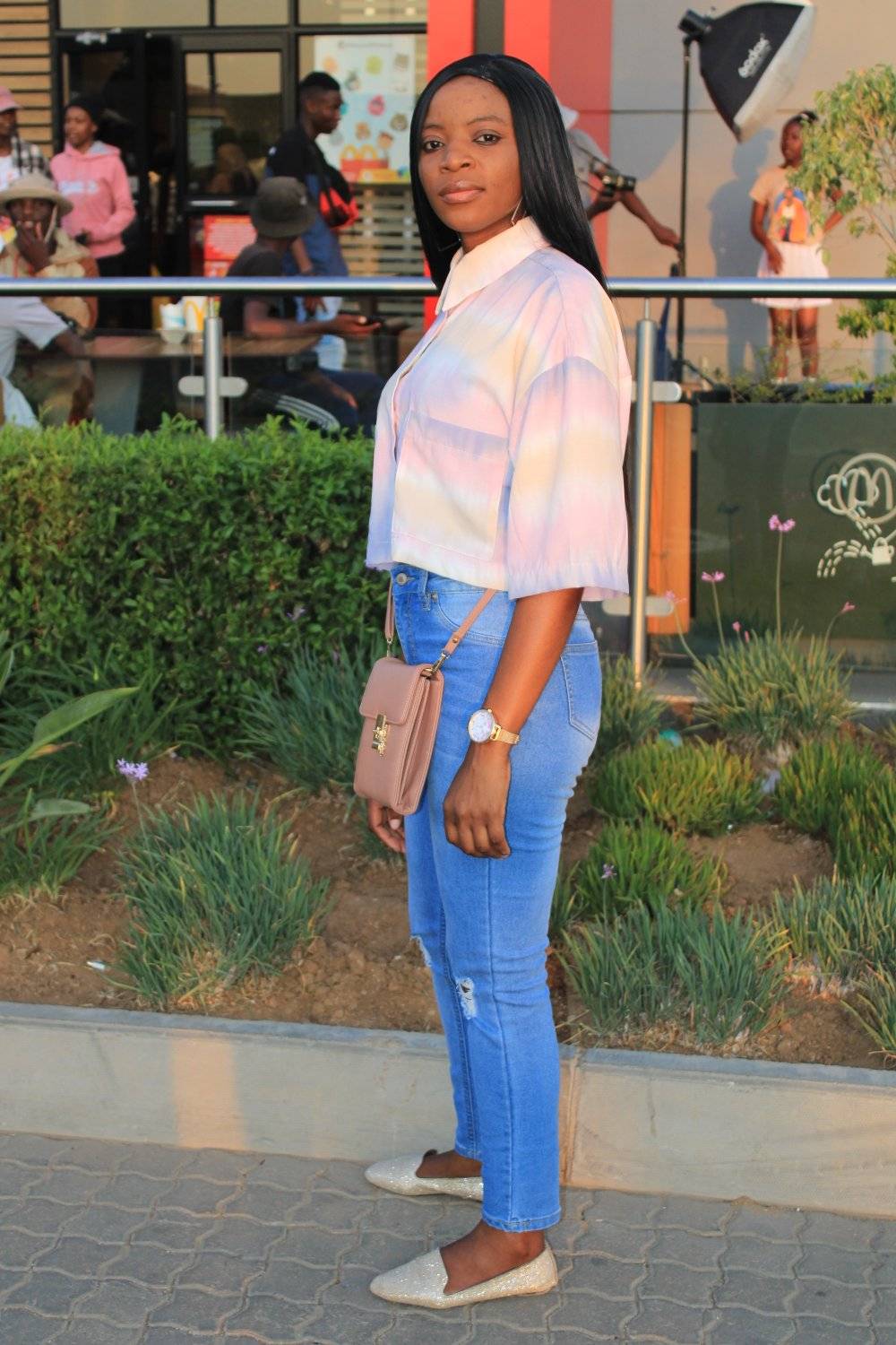 Full-length outdoor portrait in a pastel shirt and jeans