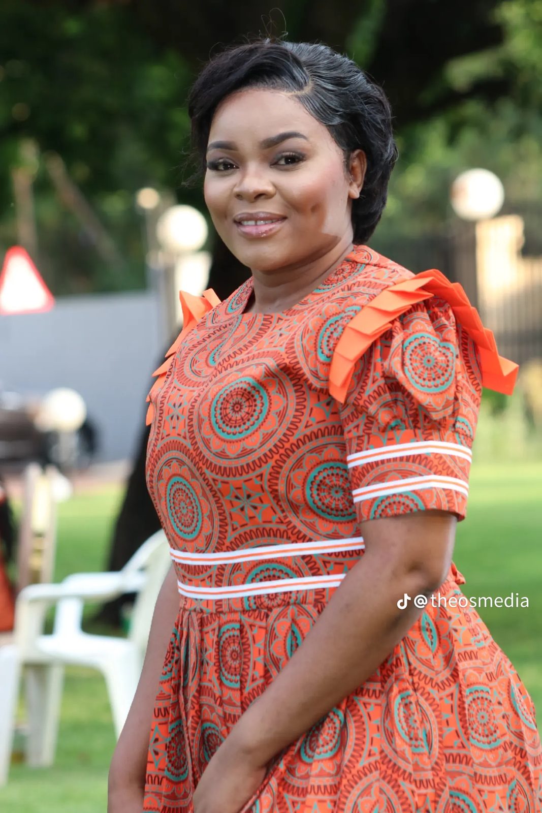 Close outdoor portrait of a woman in an orange patterned dress