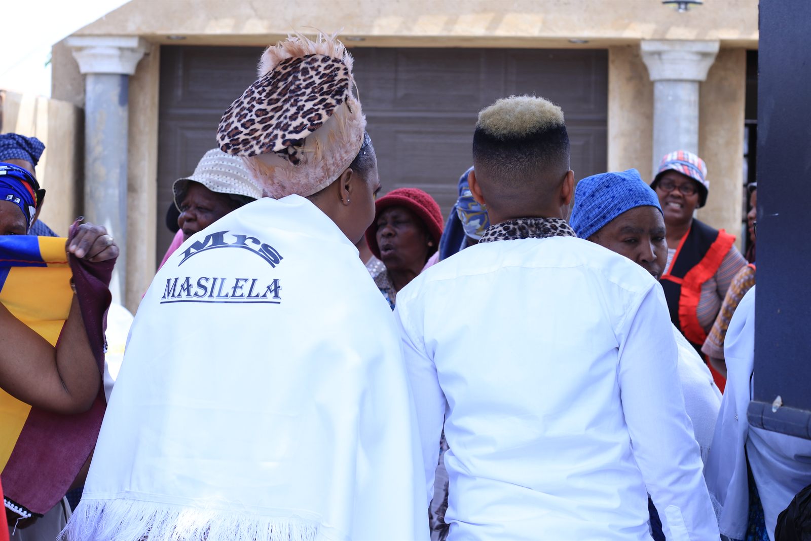 A traditional celebration, photographed from behind a white embroidered shawl